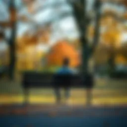 A person sitting on a park bench, deep in thought, surrounded by trees and autumn leaves, representing reflection and personal growth.